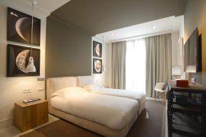 - une chambre avec un lit blanc et une fenêtre dans l'établissement Midtown Apartments, à Barcelone