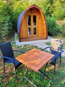 a picnic table and chairs in front of a wooden igloo at Pods Alte Schule in Elchweiler