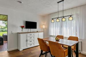 a dining room with a table and a tv at Haus am See in Königs Wusterhausen