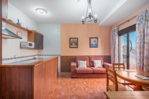 een keuken en woonkamer met een bank en een tafel bij Apartamentos Haza La Moraleda 2 y A in Güéjar-Sierra +54 foto's