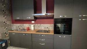 a kitchen with a sink and a stove top oven at La Finestra Rossa in Venturina Terme