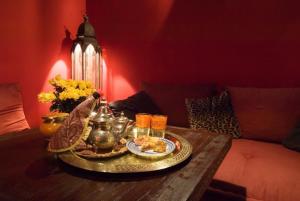 einen Tisch mit einem Tablett mit Speisen und Getränken darauf in der Unterkunft Riad La Terrasse Des Oliviers in Marrakesch