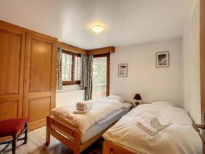 two twin beds in a room with a window at Ambassador 207 in Verbier