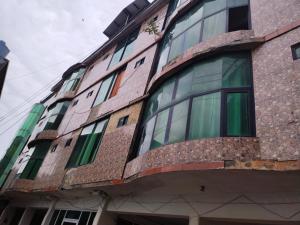 a building with glass windows on the side of it at Kashmir Continental Hotel Murree in Murree