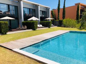 a swimming pool in front of a house at Tróia Beach Pool & Golf in Grândola
