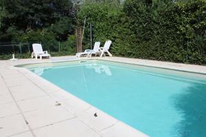 een zwembad met 2 stoelen bij Petit gite in Cours-de-Pile +18 foto's