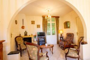 een woonkamer met een tafel en stoelen en een televisie bij Petit gite in Cours-de-Pile