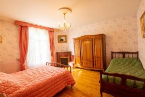 een slaapkamer met 2 bedden en een kroonluchter bij Petit gite in Cours-de-Pile