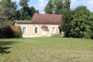 een huis in een veld met een grasveld bij Petit gite in Cours-de-Pile