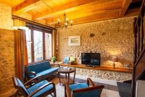 ein Wohnzimmer mit Sofa und Fernseher in der Unterkunft Le coustal in Le Clapier