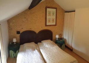 ein Schlafzimmer mit einem großen Bett mit zwei Nachttischen in der Unterkunft Le coustal in Le Clapier