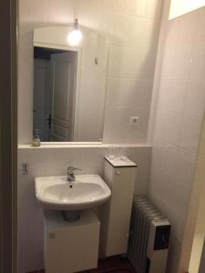 ein weißes Badezimmer mit Waschbecken und Spiegel in der Unterkunft Le coustal in Le Clapier + 8 Fotos