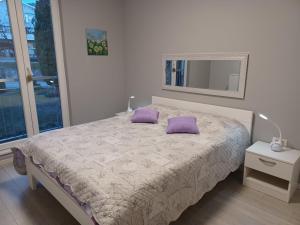 a bedroom with a bed with purple pillows on it at Apartment Fontana in Buzet