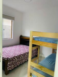 a bedroom with two bunk beds and a window at Casa Piscina Guaratuba 400mt praia in Guaratuba +8 photos