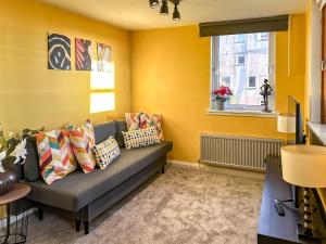 a living room with a couch and a window at Sunny day new flat with 5 beds in Clydebank
