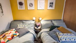 two beds sitting next to each other in a room at Sunny day new flat with 5 beds in Clydebank