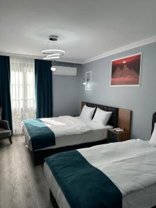 a hotel room with two beds and a chair at Asgard Hotel in Beylikduzu +23 photos