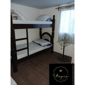a bedroom with two bunk beds and a fan at Utopía in Balneario Argentino +40 photos