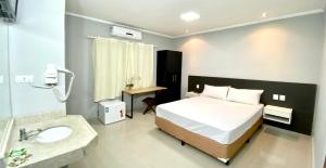 a bedroom with a bed and a bathroom with a sink at HLN Hotel - Expo - Anhembi in São Paulo