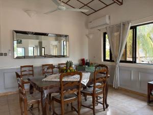 a dining room with a table and chairs and a mirror at Maison spacieuse à Grand Popo avec piscine partagée 180 m² in Grand-Popo