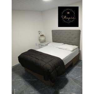 a bedroom with a bed with a black and white comforter at Utopía in Balneario Argentino