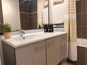 a bathroom with a white sink and a tub at AJ - Stylish Pied-à-Terre à La Joliette - Parking in Marseille +26 photos