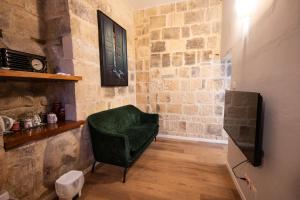 a living room with a green chair and a television at Grand Arcanum Apartment 2 - Comfortable and Elegant in Senglea +74 photos