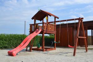 a playground with a red slide and a ladder at Jász Vendégház in Jászladány