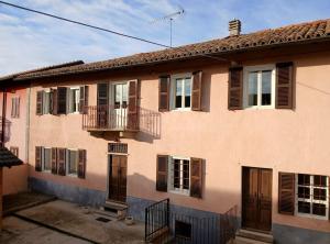 un edificio con ventanas con persianas marrones y balcón en Casa Teresina Country House, en Alfiano Natta