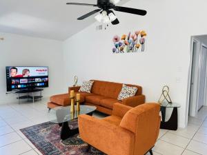Una sala de estar con un sofá y un televisor. en APluSS Getaway, en Kissimmee