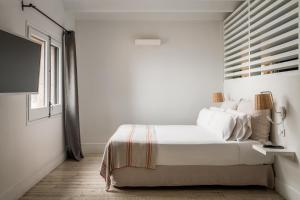 a white bedroom with a bed and a window at BYPILLOW Cap Sa Sal in Begur