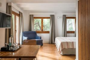 a hotel room with a bed and a blue chair at BYPILLOW Cap Sa Sal in Begur