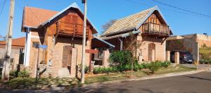 an old brick house with a balcony on a street at Casa/chalé Furnas - Capitólio MG in São José da Barra