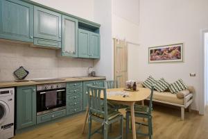 eine Küche mit grünen Schränken sowie einem Tisch und Stühlen in der Unterkunft Merulana Suite Apartment in Rom