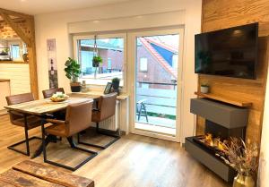 a dining room with a table and a fireplace at Ferienwohnung Auszeit Norddeich I 5 Minuten zu Fuß zum Meer in Norddeich