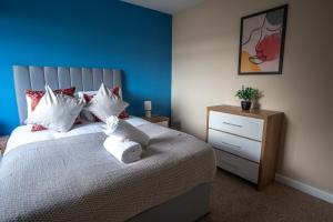 a bedroom with a bed with a teddy bear on it at Castlefern House in Rutherglen