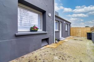 a building with a window with a potted plant on it at Les Pivoines Magiques - Maison avec garage in Marquise +5 photos