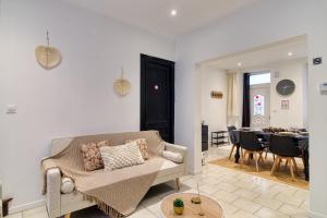 a living room with a couch and a dining room at Les Pivoines Magiques - Maison avec garage in Marquise