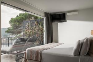 a bedroom with a bed and a balcony with a view at BYPILLOW Cap Sa Sal in Begur