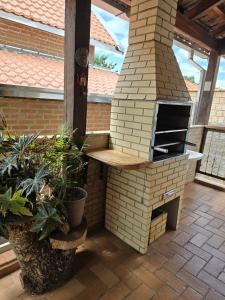 an outdoor pizza oven on a patio with plants at Casa/chalé Furnas - Capitólio MG in São José da Barra