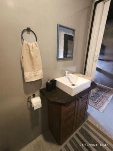 a bathroom with a sink and a mirror at Apartamento suíte com cozinha in Penha +8 photos