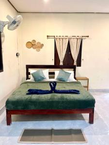 a bedroom with a large bed with a green blanket at Khao Sok Green Mountain View in Khao Sok National Park