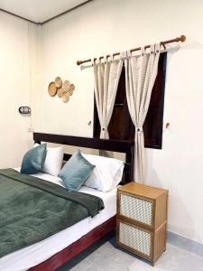 a bedroom with a bed and a window with curtains at Khao Sok Green Mountain View in Khao Sok National Park