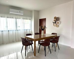 a dining room with a wooden table and chairs at Luna villa Chaweng Samui in Nathon Bay