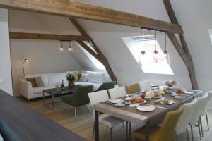 a dining room with a table and chairs and a couch at Wilgenwind in Sijsele