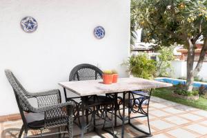 drewniany stół i krzesła na patio w obiekcie Villa Ana María w mieście Torremolinos