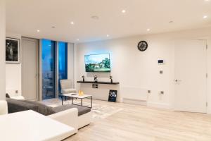 曼彻斯特Luxury 2 Bed Penthouse with Stunning Views in Manchester City Centre的客厅里有一张沙发，墙上挂着一只钟