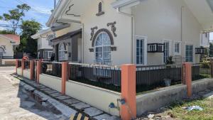 a house with a fence in front of it at Balay Hermosa in Dauis