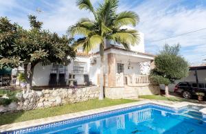 dom z palmą i basenem w obiekcie Villa Ana María w mieście Torremolinos