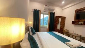 a hotel room with a bed and a window at GreenDay Escapes Rishikesh in Rishīkesh